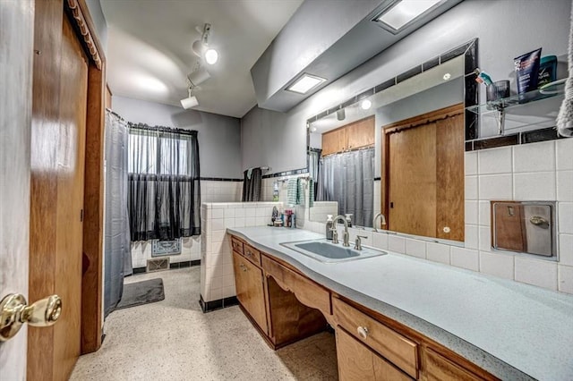 bathroom featuring backsplash, vanity, and tile walls