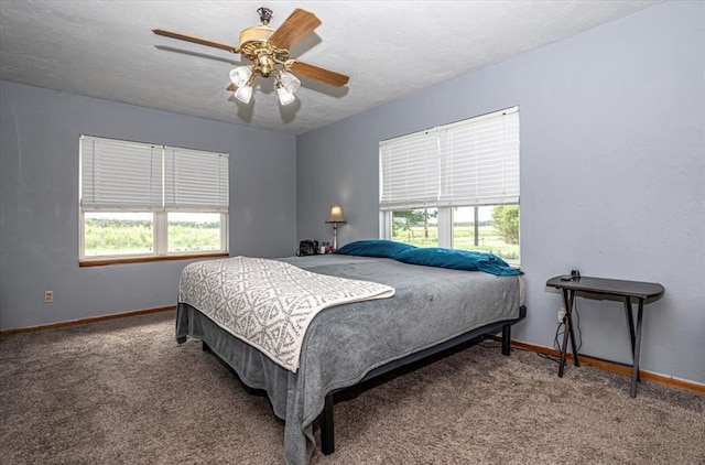 carpeted bedroom with multiple windows, a textured ceiling, and ceiling fan