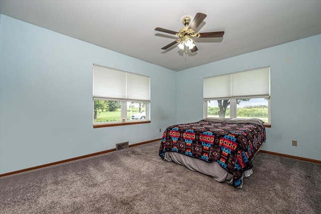 carpeted bedroom featuring multiple windows and ceiling fan