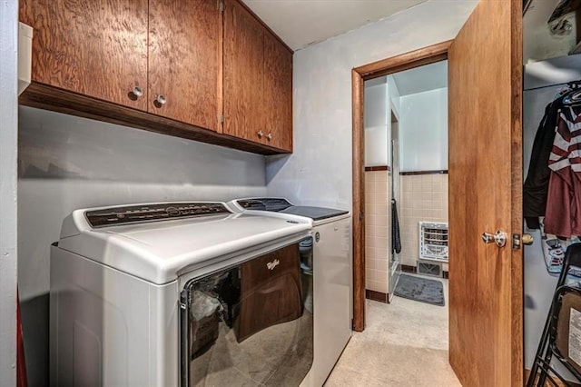 laundry room with cabinets and washing machine and clothes dryer