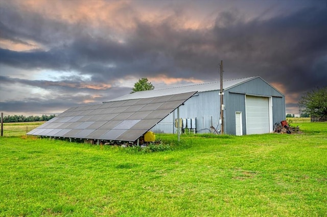 outdoor structure at dusk with a lawn and solar panels