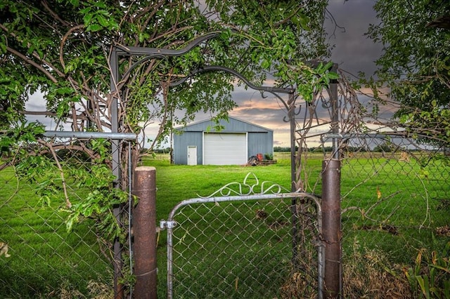 yard at dusk featuring an outdoor structure and a garage