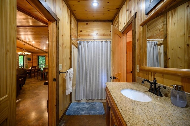 bathroom featuring a shower with shower curtain, vanity, wooden walls, and wood ceiling