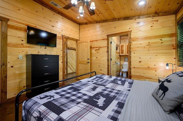 bedroom featuring connected bathroom, wood-type flooring, lofted ceiling, wooden walls, and wood ceiling