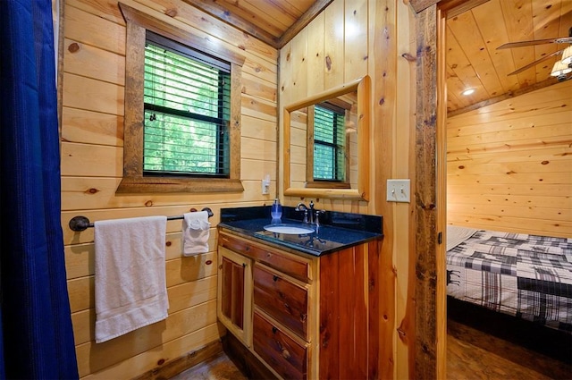 bathroom with vanity, wood walls, vaulted ceiling, ceiling fan, and wood ceiling