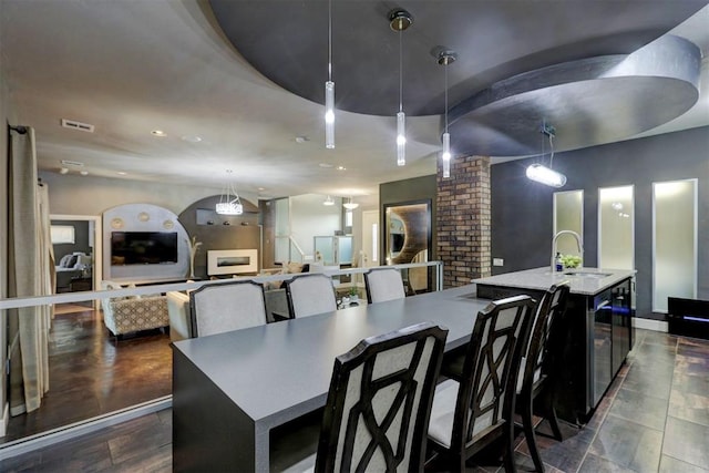 dining space with decorative columns, sink, and dark hardwood / wood-style floors