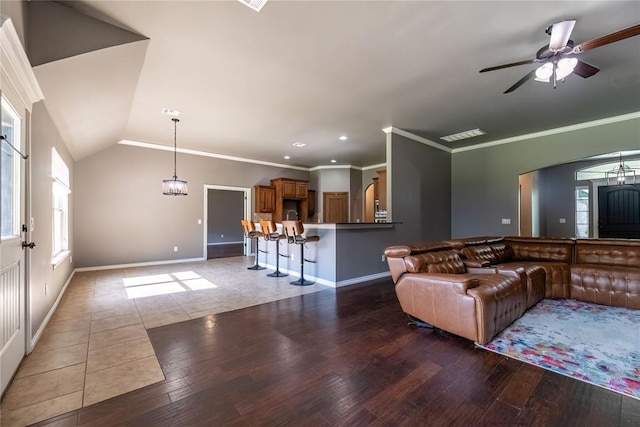 living room with hardwood / wood-style flooring, crown molding, and vaulted ceiling