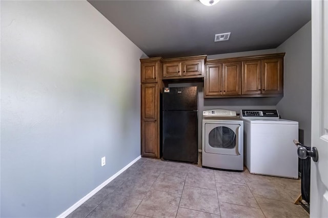 laundry area with cabinets, independent washer and dryer, and light tile patterned floors