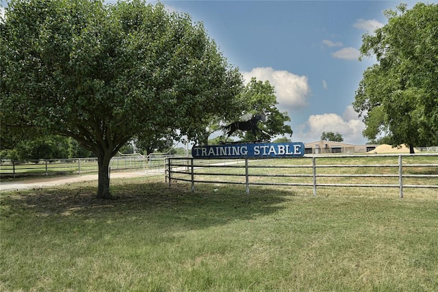 view of gate with a yard and a rural view