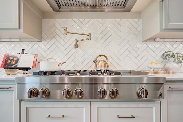 kitchen with decorative backsplash, ventilation hood, white cabinetry, and stainless steel gas stovetop