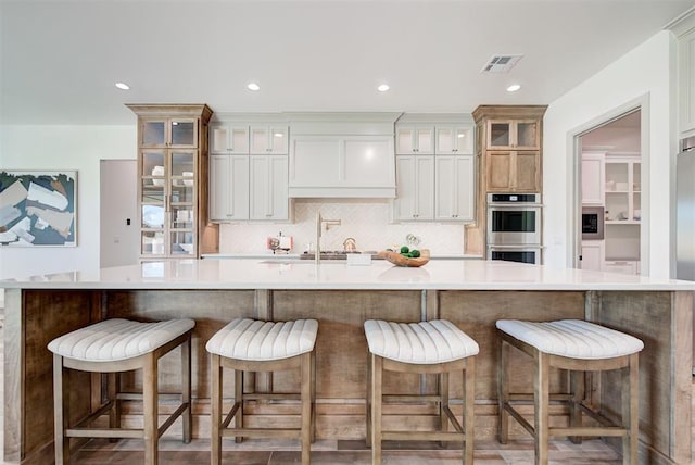 kitchen featuring a breakfast bar, stainless steel double oven, and a large island