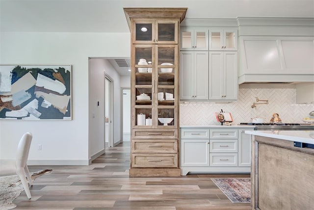 kitchen featuring tasteful backsplash, white cabinetry, and light hardwood / wood-style floors