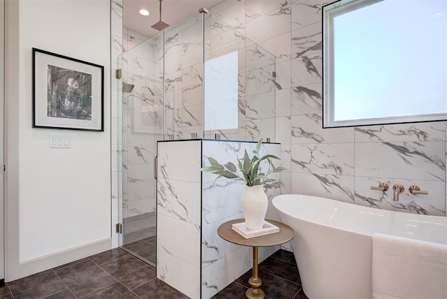 bathroom featuring plus walk in shower, a wealth of natural light, and tile walls