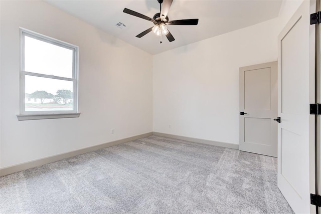 carpeted spare room featuring ceiling fan