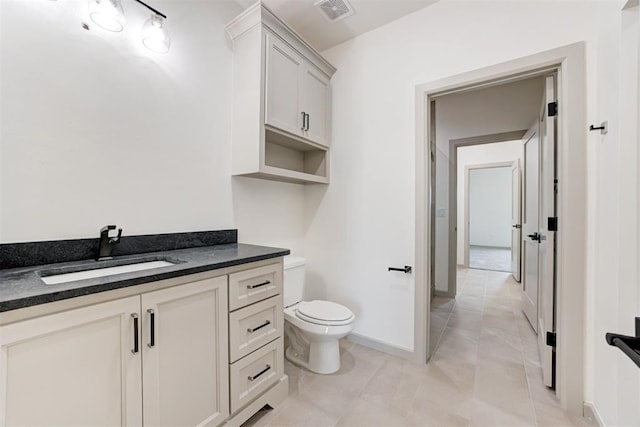 bathroom featuring tile patterned flooring, vanity, and toilet