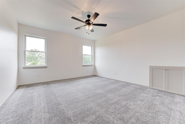 empty room featuring ceiling fan and light colored carpet