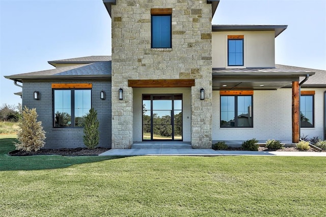 rear view of property featuring a lawn