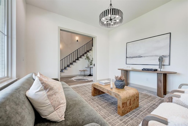 living room featuring wood-type flooring and a notable chandelier