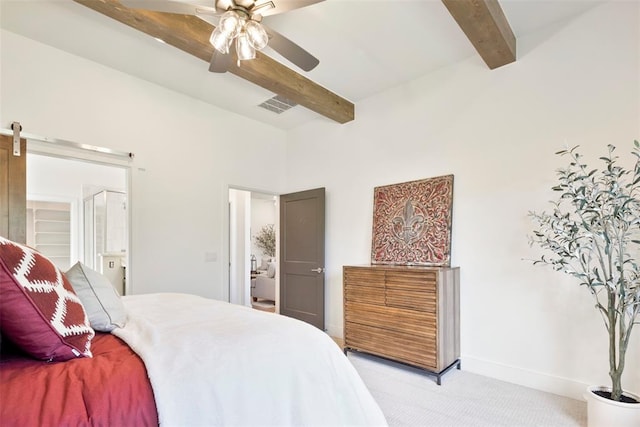 bedroom featuring beam ceiling, ensuite bath, ceiling fan, and light colored carpet