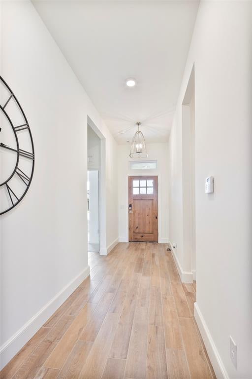 foyer with light hardwood / wood-style floors and a notable chandelier