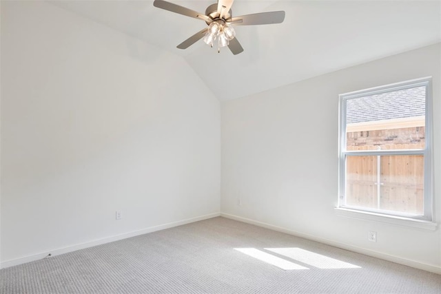 carpeted empty room with ceiling fan and vaulted ceiling