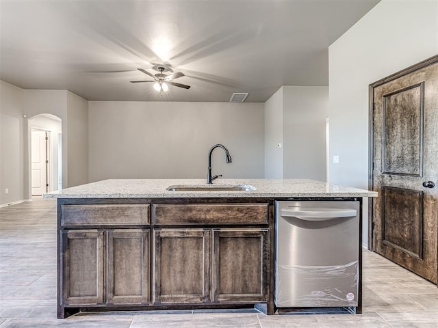 kitchen with dark brown cabinetry, an island with sink, and sink