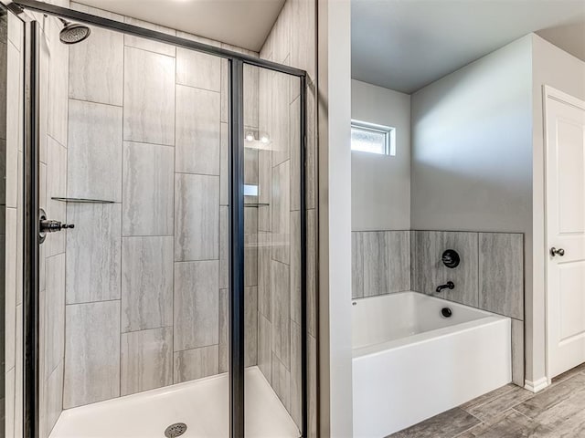 bathroom featuring wood-type flooring and shower with separate bathtub