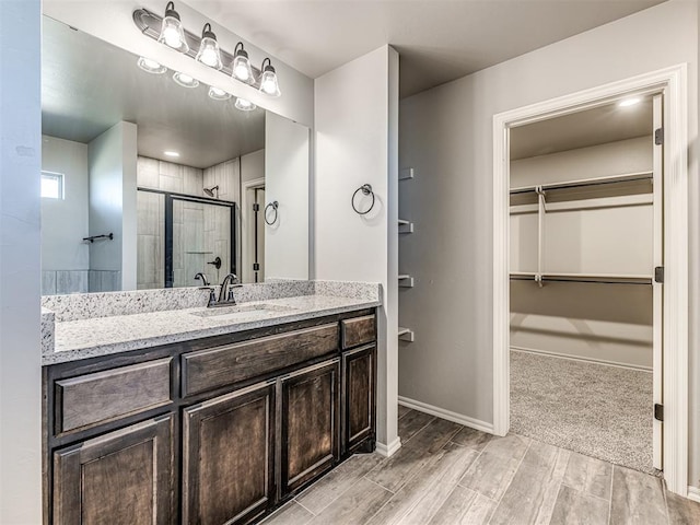 bathroom featuring hardwood / wood-style flooring, vanity, and a shower with door