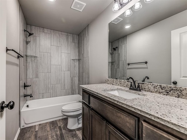 full bathroom featuring vanity, toilet, wood-type flooring, and tiled shower / bath