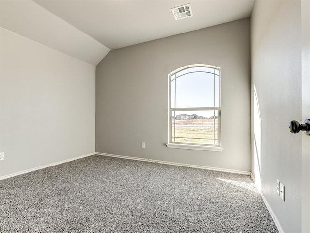 carpeted empty room featuring vaulted ceiling