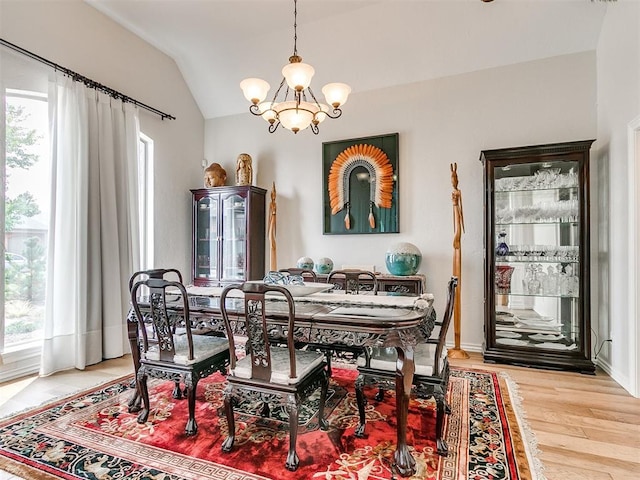 dining room featuring hardwood / wood-style flooring, an inviting chandelier, a wealth of natural light, and lofted ceiling