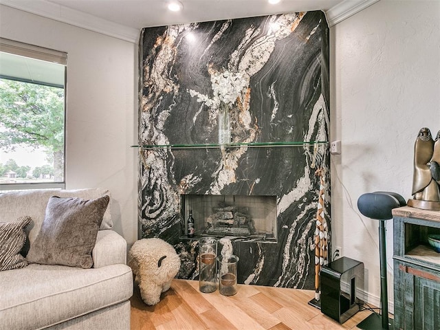 sitting room with hardwood / wood-style flooring, a fireplace, and crown molding