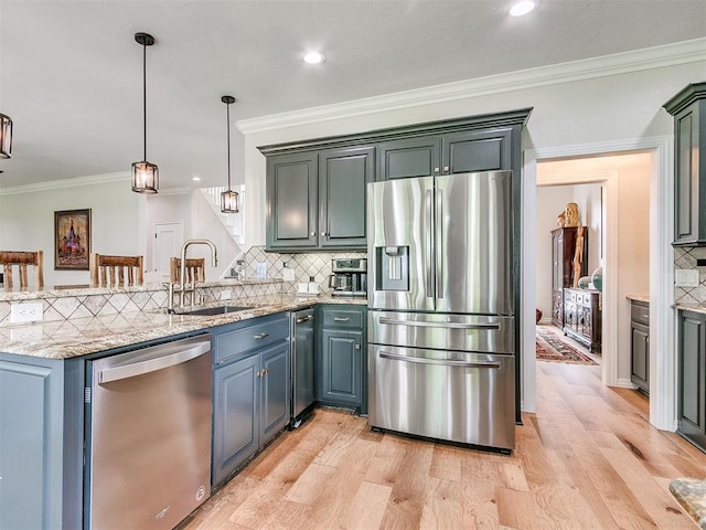 kitchen with kitchen peninsula, appliances with stainless steel finishes, sink, light hardwood / wood-style flooring, and hanging light fixtures