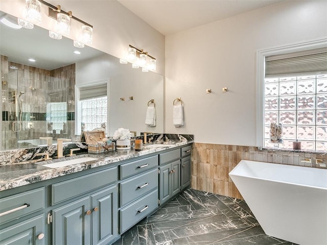 bathroom featuring vanity, separate shower and tub, and tile walls