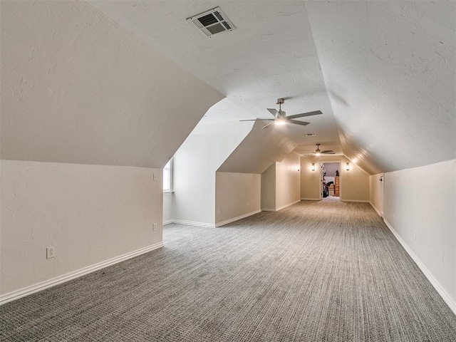 additional living space featuring carpet, ceiling fan, a textured ceiling, and vaulted ceiling