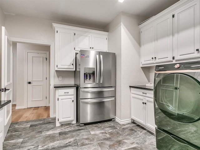 kitchen with stainless steel fridge with ice dispenser, light hardwood / wood-style flooring, white cabinetry, and washer / dryer