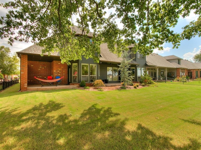 back of house featuring a lawn and a patio