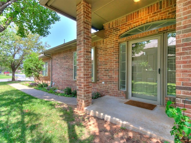 view of exterior entry featuring a lawn