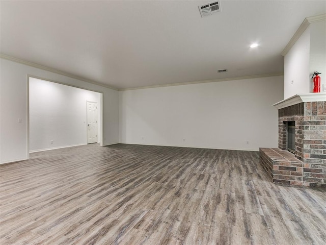 unfurnished living room with light wood-type flooring, a fireplace, and ornamental molding