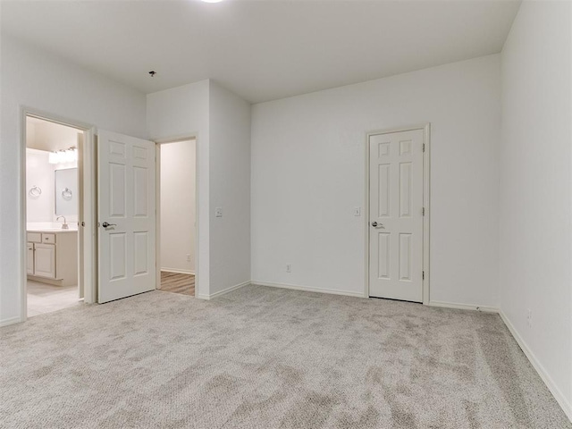 unfurnished bedroom featuring light colored carpet, sink, and a closet