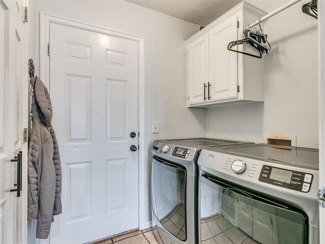 laundry area featuring cabinets, washer and dryer, and light tile patterned flooring