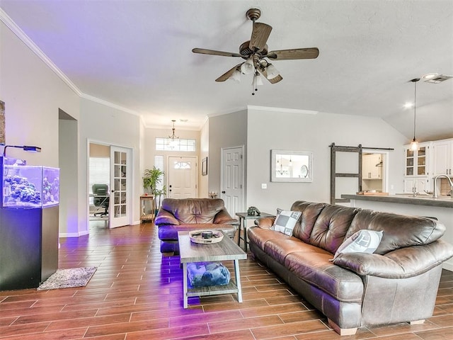 living room with ceiling fan, a barn door, and light hardwood / wood-style flooring