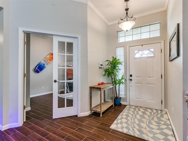 foyer entrance with crown molding and dark wood-type flooring