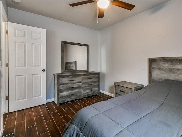 bedroom with dark hardwood / wood-style flooring and ceiling fan