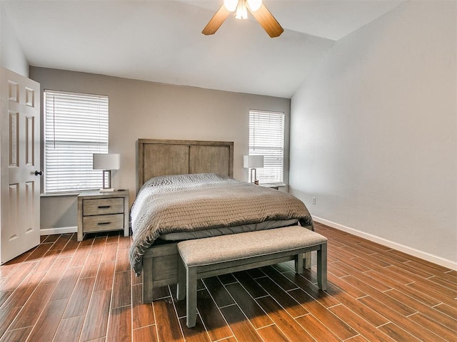 bedroom with dark hardwood / wood-style flooring, vaulted ceiling, and ceiling fan