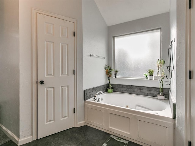 bathroom with a tub and vaulted ceiling