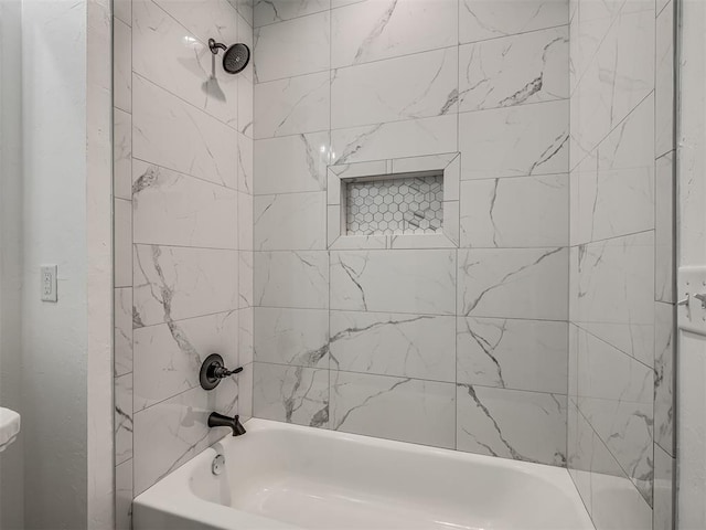 bathroom featuring toilet and tiled shower / bath