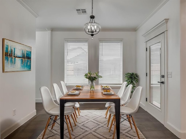 dining space featuring dark hardwood / wood-style floors, ornamental molding, and an inviting chandelier