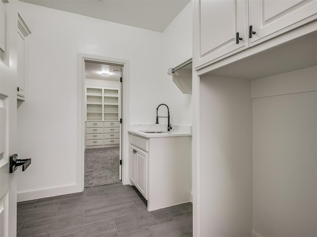 laundry area featuring sink and carpet flooring