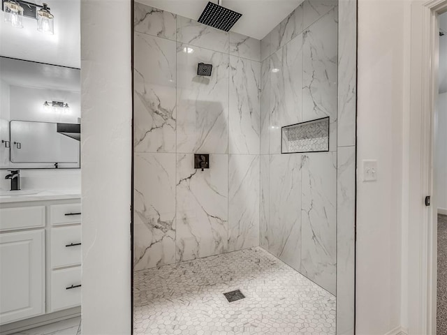 bathroom featuring a tile shower and vanity